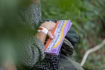 Female hands holding Vamvakou Experience Festival tickets.